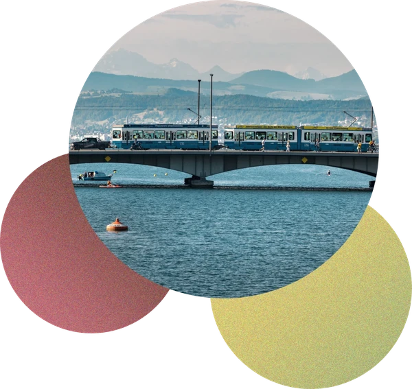 Zürich tram crossing a bridge over the lake with mountains in the background